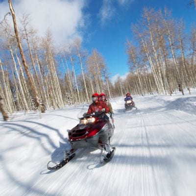 Couples Racing on Snowmobiles